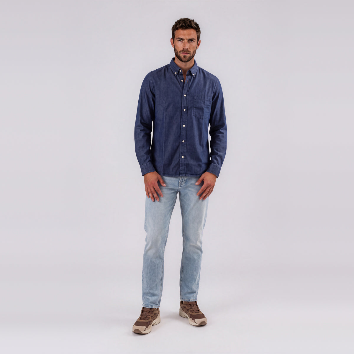 Man wearing Garment Works dark denim button down shirt with light wash jeans