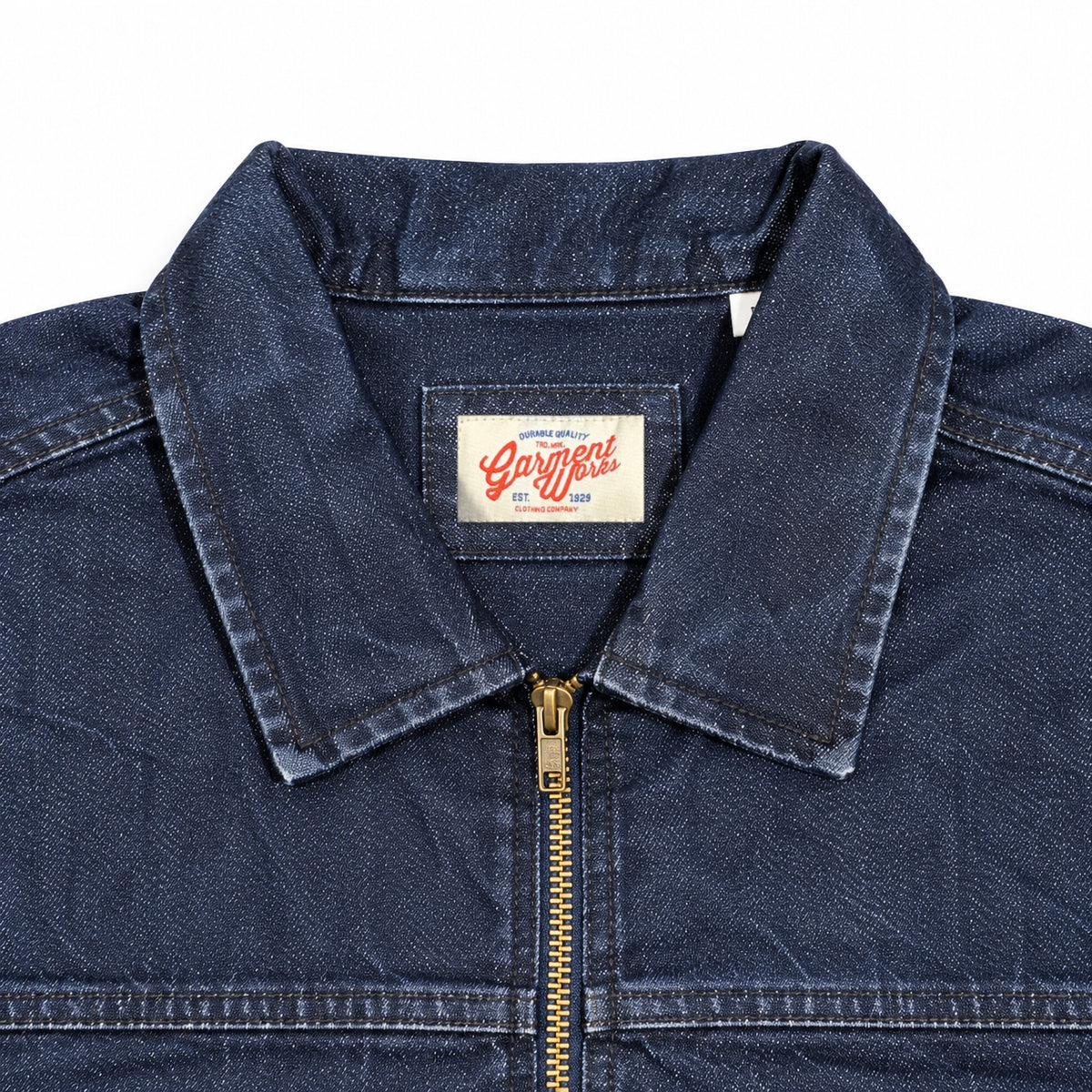 Close-up of Sycamore indigo denim jacket collar, brass zip and Garment Works label